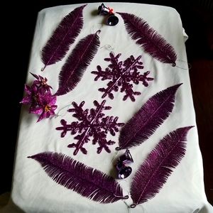 Metalic purple snowflake ornaments and purple feathers.